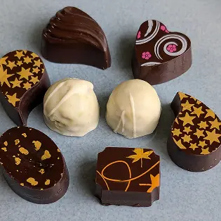 two oval chocolate pieces with white drizzle representing the perfected palate of the chocolates
