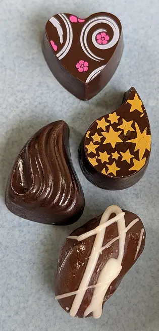 Four chocolate pieces arranged in a tall stack representing the business owner and her chocolate making process.